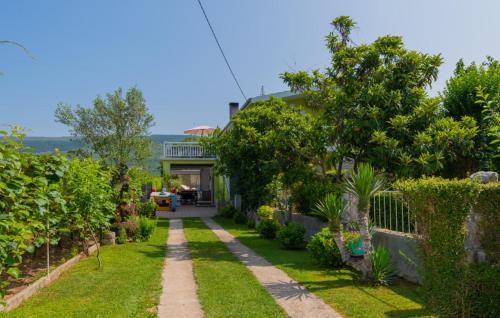 a house with a yard with grass and trees at Beautiful Villa Vrljika with pool in Makarska in Grubine
