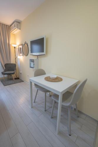 a white table and chairs in a room with a tv at Amber Apartman in Banja Koviljača