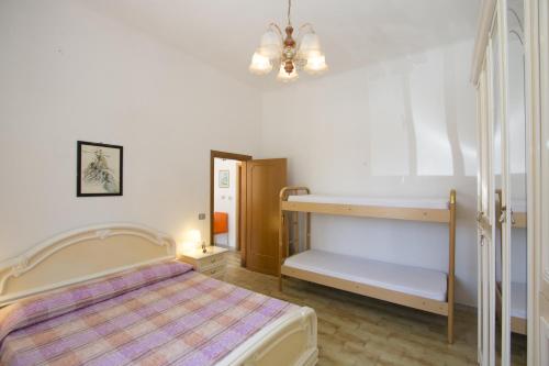 アルバ・アドリアティカにあるVilletta Lungomareの白いベッドルーム(ベッド1台、二段ベッド1組付)