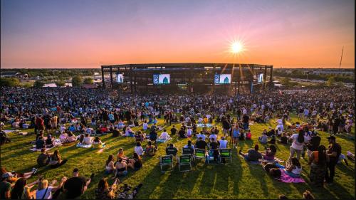 a crowd of people sitting on the grass in front of a concert at Modern Retreat with Private Pool & Yard, 10 mins to Tinley Ampitheatre home 