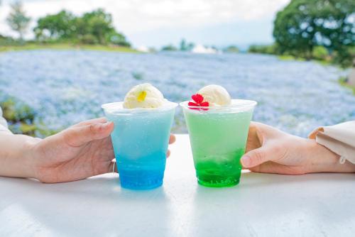 two people sitting at a table with two drinks at くじゅう花公園 グランピングパーク花と星 in Kuju