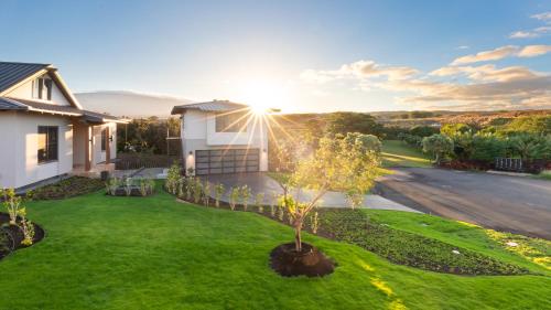 a house with a tree in the yard at MAUNA KEA BEACH ESCAPE Luxurious home in private community with Heated Private Pool and Spa Detached Ohana Suite in Waimea