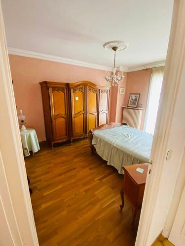 una camera da letto con un letto e un pavimento in legno di Maison de vacances a La Celle-sous-Gouzon