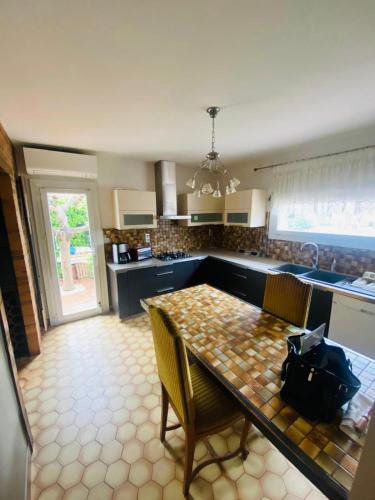 una cucina con tavolo e sedie e una cucina con lavello di Maison de vacances a La Celle-sous-Gouzon