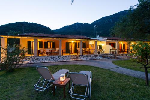 a house with chairs and a table in the yard at Renata Rooms & Studios in Barbati