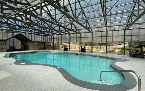 a large swimming pool in a building with a glass ceiling at Boo Boos Den in Sevierville