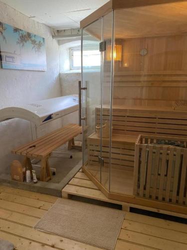 a sauna with a tub and a bench in a room at FeWo Auszeit Andreas Schreiner in Arrach