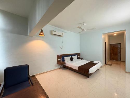 a bedroom with a bed and a chair in it at Lions Den Resort Lonavala in Lonavala