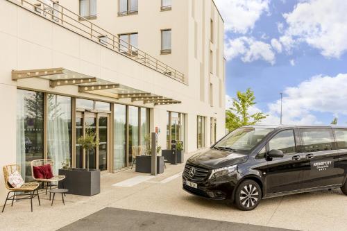 a black car parked in front of a building at Appart'City Collection Paris Roissy CDG Airport in Roissy-en-France