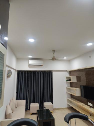 a living room with a couch and a tv at Aasra in Dehu Road
