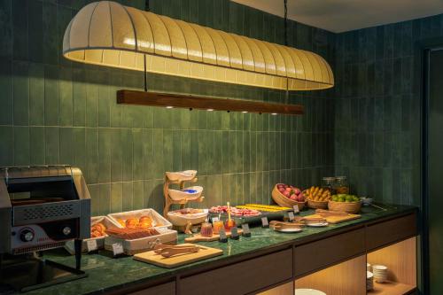 una cocina con buffet de comida en una barra en M Village Hotel Nguyễn Du, en Ho Chi Minh