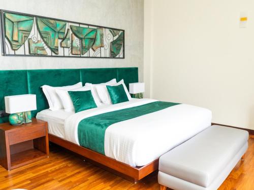a bedroom with a large bed with a green headboard at Seraphic Hills in Haputale