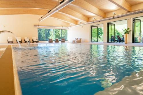 a swimming pool with water in a building at Best Western Ahorn Hotel Oberwiesenthal – Adults Only in Kurort Oberwiesenthal