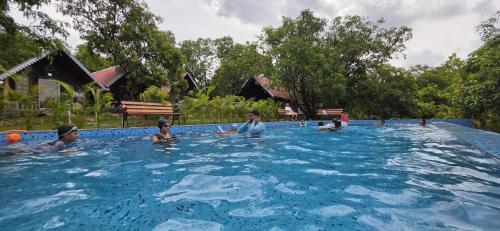a group of people in a swimming pool at Trio Farm serenity home vibe in Sawantwadi