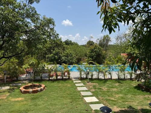 a garden with a pool in the background at Trio Farm serenity home vibe in Sawantwadi