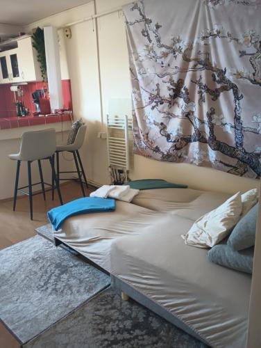 a bedroom with a large bed and a kitchen at Cosy Nest on Floor 4 of 4 in Satu Mare