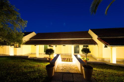 a house with two potted trees in front of it at Renata Rooms & Studios in Barbati