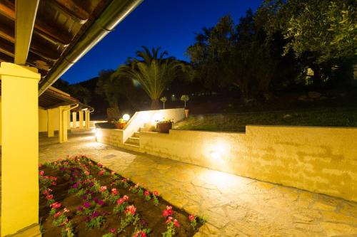a garden with pink flowers on a patio at night at Renata Rooms & Studios in Barbati