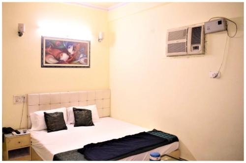 a small room with a bed and a air conditioner at HOTEL DS STAY VARANASI ! - Near Kasi Vishwanath Temple And Ganga Ghat #Fully Air Conditioning #Free Wi-Fi #Parking #Room Service #Prime Location - Best Selling Premium Hotel in Varanasi in Varanasi