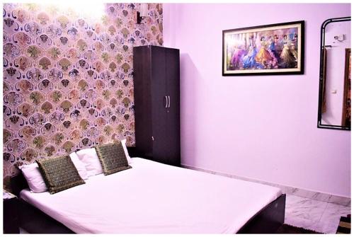 a bedroom with a white bed with a wall at HOTEL DS STAY VARANASI ! - Near Kasi Vishwanath Temple And Ganga Ghat #Fully Air Conditioning #Free Wi-Fi #Parking #Room Service #Prime Location - Best Selling Premium Hotel in Varanasi in Varanasi