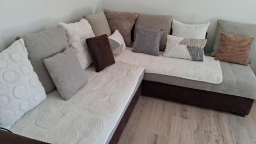 a couch with many pillows on it at Chambre privée dans maison partagée in Montélimar