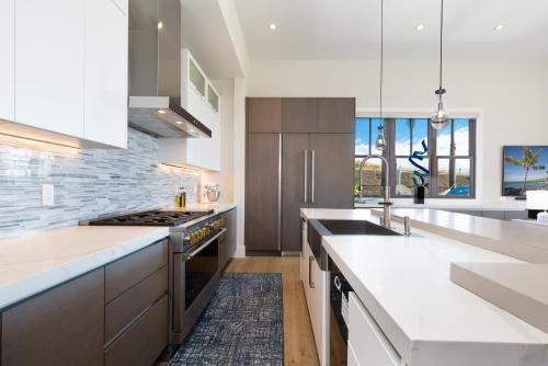 a kitchen with white counters and a sink and a stove at BLUE SERENITY Luxurious home in private community with Heated Private Pool Spa Detached Ohana Suite in Waimea