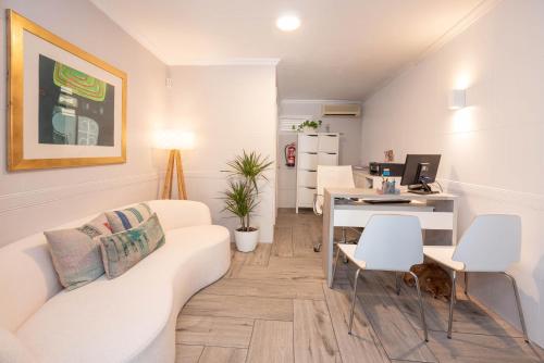 a living room with a couch and a desk with a computer at Hostal Costa in Ibiza Town