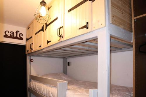 - un lit superposé avec une lumière au-dessus dans l'établissement Résidence L'oustal - Joli studio 4 personnes MAE-2774, aux Orres