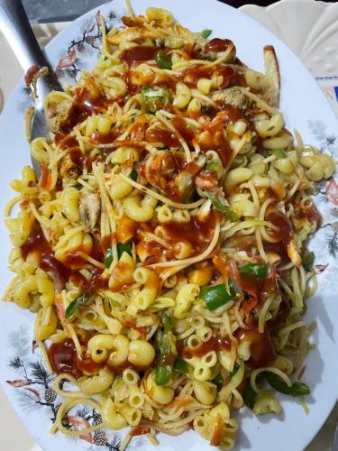 a plate of pasta with meat and sauce at Mountain Dale Guest House in Gilgit