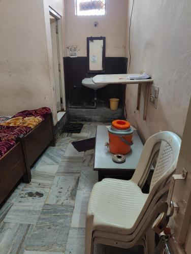 a small room with a bed and a table and chairs at hotel aadarsh in Sendhwa
