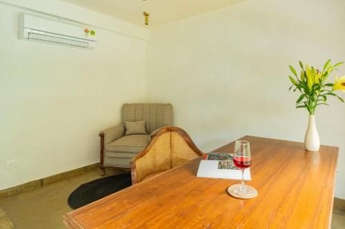 a wooden table with a glass of wine on it at Luxury Villa With Private Pool, 4-BHK, Assagao in Assagao