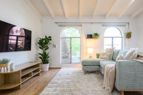 a living room with a blue couch and two windows at 5 Beach Baby Bungalow & Parking in Perth
