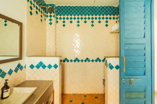 a bathroom with a shower and a blue door at Luxury Villa With Private Pool, 4-BHK, Assagao in Assagao