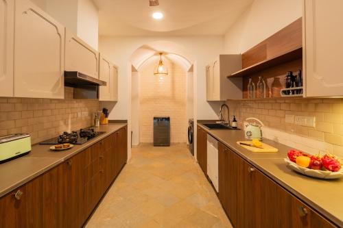 a kitchen with wooden cabinets and a bowl of fruit on the counter at Luxury Villa With Private Pool, 4-BHK, Assagao in Assagao