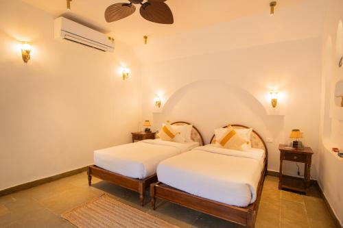 a bedroom with two beds and a ceiling fan at Luxury Villa With Private Pool, 4-BHK, Assagao in Assagao