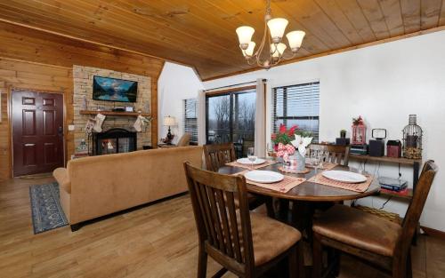 a dining room and living room with a table and chairs at Holly Tree Cabin 936 in Gatlinburg