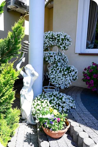 a statue of a woman next to a bunch of flowers at Hotel Gracja in Brok