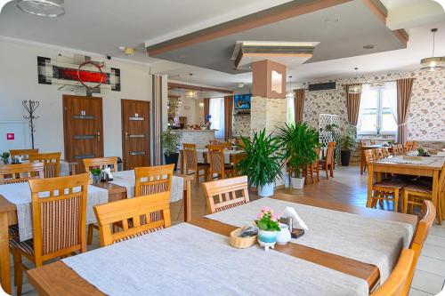 a restaurant with wooden tables and wooden chairs at Hotel Gracja in Brok