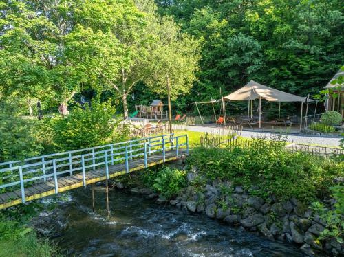 a bridge over a river with a table and a tent at Landal Nature Parc Saint Hubert in Grosse Haye