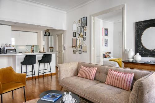 un salon avec un canapé et une cuisine dans l'établissement Escale citadine au centre d'Avignon, climatisation, appartement de charme, spacieux et lumineux, à Avignon