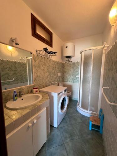 a bathroom with a washing machine and a washer at Casa Janas, Palau, Costa Smeralda in Palau