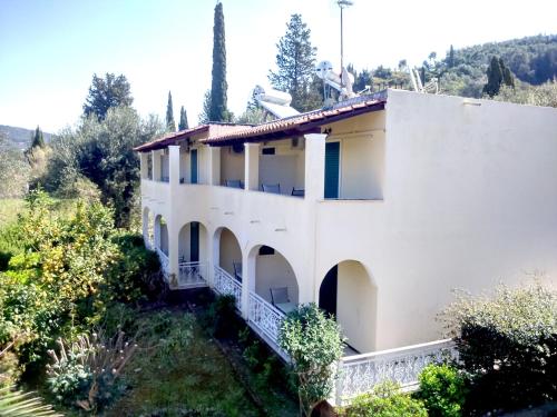 a white house with trees in the background at Villa Thomas in Agios Georgios Pagon