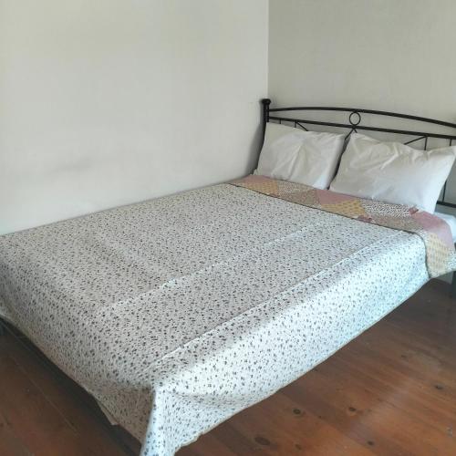 a bedroom with a bed with a black and white bedspread at Agios Dimitrios House in Plomarion