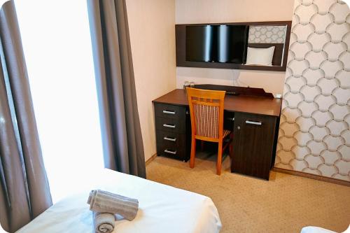 a hotel room with a desk with a chair and a bed at Hotel Gracja in Brok