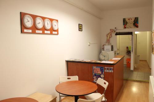 a kitchen with a table and two chairs and a clock on the wall at Fanni Budapest Guesthouse in Budapest