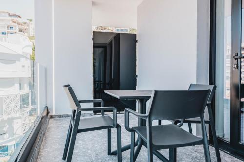 a table and chairs in a room with windows at Boe Luxury Hotel in Sarandë