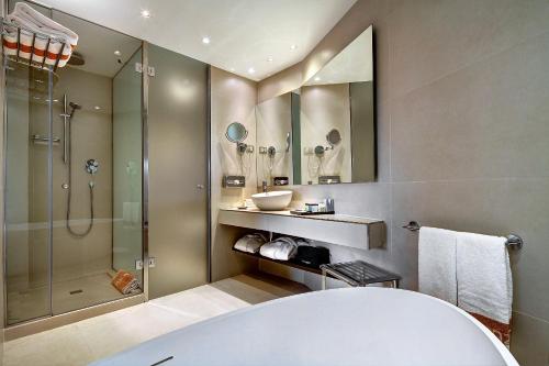 a bathroom with a tub and a shower and a sink at Palace Bonanza Playa Resort & SPA by Olivia Hotels Collection in Illetas