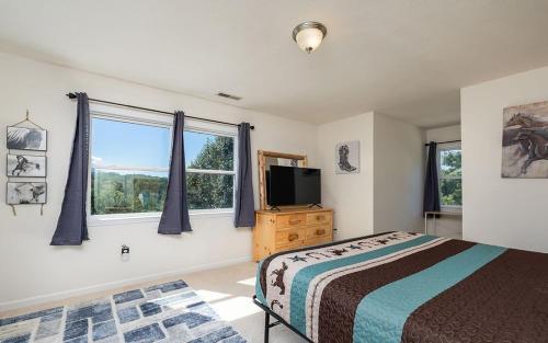 赛维尔维尔Shadow Ridge Retreat的一间带床、电视和窗户的卧室