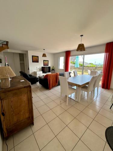 un salon avec une table, des chaises et un canapé dans l'établissement La Maison Bleue, à Saint-Avé