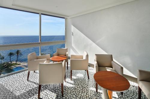 a room with a table and chairs and the ocean at Palace Bonanza Playa Resort & SPA by Olivia Hotels Collection in Illetas